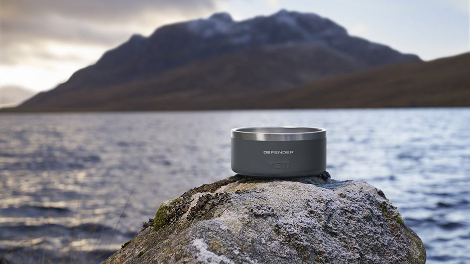 YETI dog bowl on a rock next to a loch