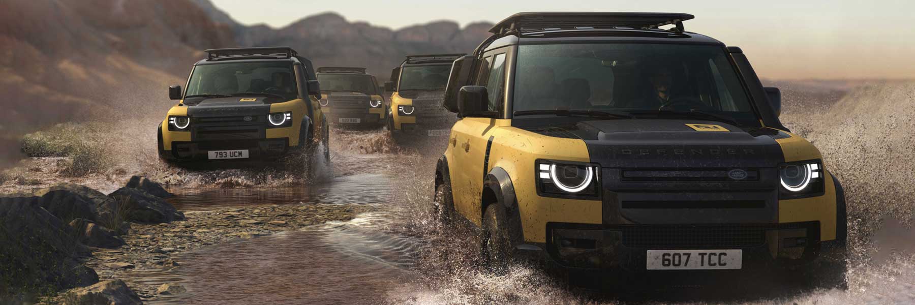Defender Trophy hero banner four Trophy liveried Defenders powering through a river showcasing their awesome capability.